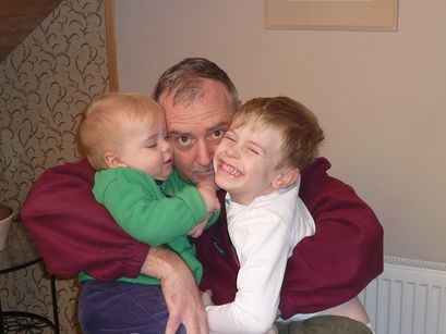 Dad squeezing the boys. 
